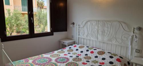 a bedroom with a bed with a quilt on it at Arbatax Apartment in Àrbatax