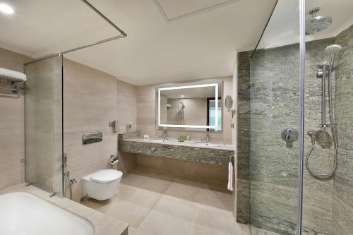 a bathroom with a shower and a toilet and a sink at Hilton Hurghada Plaza Hotel in Hurghada