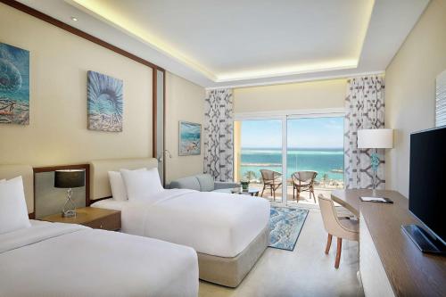a hotel room with two beds and a view of the ocean at Hilton Hurghada Plaza Hotel in Hurghada