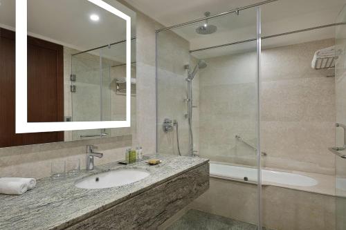 a bathroom with a sink and a shower at Hilton Hurghada Plaza Hotel in Hurghada