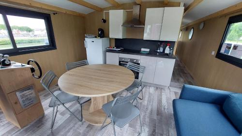 - une cuisine et une table avec des chaises dans la chambre dans l'établissement Bateau solaire, à Castelfranc