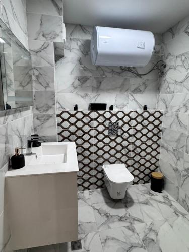 a bathroom with a white sink and a toilet at Spacious sunny flat with 2 bedrooms in the heart of Plovdiv in Plovdiv