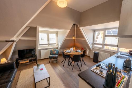 a living room with a kitchen and a table at Zeehuis Appartement & Studio in Zandvoort