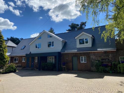 a house with a blue roof on a driveway at Petherton Cottage Studios in Ringwood