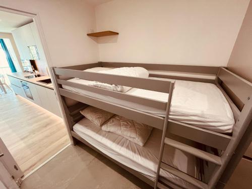 une chambre avec deux lits superposés dans une pièce dans l'établissement Noble Escale, Plage et Parking, à La Grande Motte