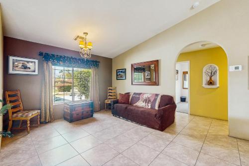 a living room with a couch and a window at Cool Pool Retreat in Bermuda Dunes