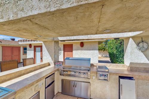 an outdoor kitchen with a stove and a counter top at Cool Pool Retreat in Bermuda Dunes