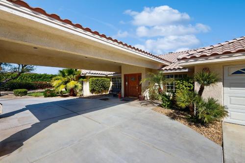a house with a driveway leading to a garage at Cool Pool Retreat in Bermuda Dunes
