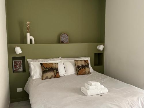 a green bedroom with a bed with towels on it at Don Nicuzzo in Salemi