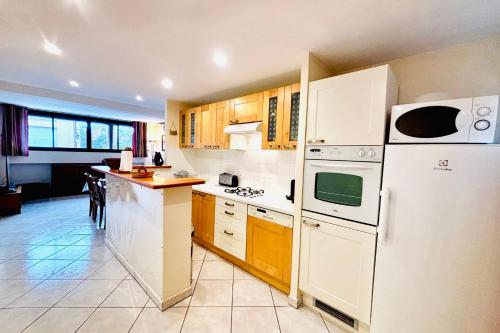 une cuisine avec des appareils électroménagers blancs et des armoires en bois dans l'établissement Le République - Centre Collioure - Wifi, à Collioure