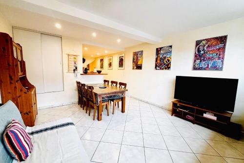 un salon avec une table à manger et une télévision dans l'établissement Le République - Centre Collioure - Wifi, à Collioure