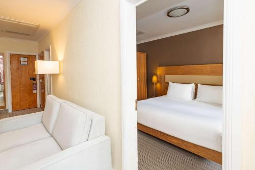 a hotel room with a bed and a couch at Hilton London Olympia in London
