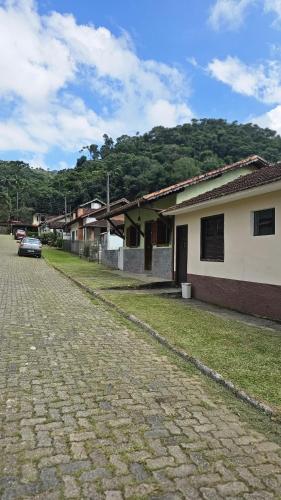 une rue pavée dans une ville avec des maisons et une voiture dans l'établissement Casa da Vila, Charme e Conforto no Coração de Visconde de Mauá, à Visconde de Mauá