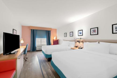 a hotel room with two beds and a flat screen tv at Hilton Garden Inn Lexington Georgetown in Georgetown