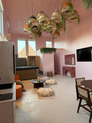 un grand salon avec des chaises, des tables et des lumières dans l'établissement VillaNoor&Spa AdultOnly, à Les Moëres