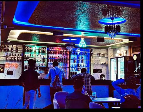 a group of people standing at a bar at Golden Bar And Hotel in Sandīla