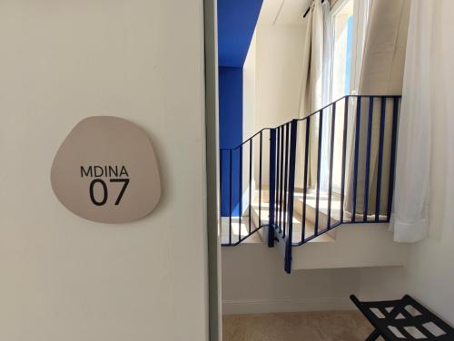 a clock on a wall next to a staircase at Alba in Sliema