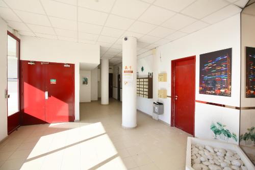 a hospital hallway with red doors and a pillar at expat renting - Le Dolce Vita - Netflix in Toulouse