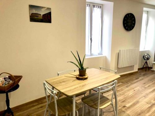 d'une table à manger avec des chaises et une plante. dans l'établissement Apparement au centre de Semur en Auxois, à Semur-en-Auxois