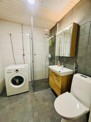 a bathroom with a washing machine and a sink at Quiet Private Rooms Easy Metro & Airport Access in Vantaa