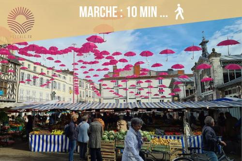 un marché avec des parapluies rouges suspendus au-dessus d'un marché dans l'établissement Gare et vieux port, à La Rochelle