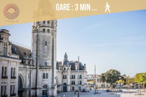 un bâtiment avec une tour d'horloge devant lui dans l'établissement Gare et vieux port, à La Rochelle