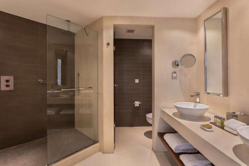 a bathroom with a shower and a sink and a toilet at Hilton Malta in St Julian's