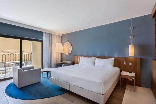 a hotel room with a bed and a balcony at Hilton Malta in St Julian's