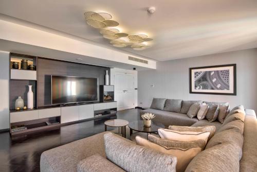 a living room with a couch and a flat screen tv at Hilton Malta in St Julian's