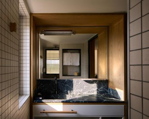 a bathroom with a sink and a mirror at Ace Hotel & Swim Club Athens in Athens