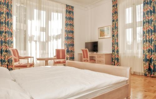 Augustenhof في باد إلستر: غرفة نوم بسرير وطاولة وكراسي
