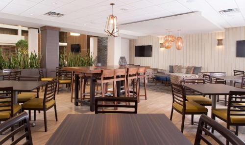 a restaurant with tables and chairs and a couch at Embassy Suites by Hilton Bloomington/Minneapolis in Bloomington
