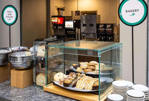 a bakery with a display case with various pastries at Embassy Suites by Hilton Bloomington/Minneapolis in Bloomington