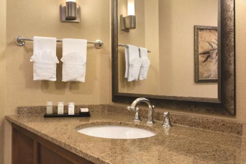 a bathroom with a sink and a mirror and towels at Embassy Suites by Hilton Bloomington/Minneapolis in Bloomington