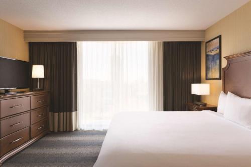 a hotel room with a bed and a large window at Embassy Suites by Hilton Bloomington/Minneapolis in Bloomington