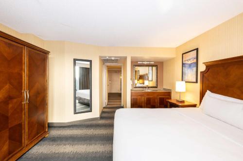 a hotel room with a bed and a bathroom at Embassy Suites by Hilton Bloomington/Minneapolis in Bloomington