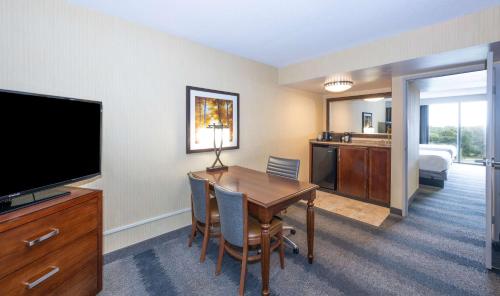 a hotel room with a table and a television at Embassy Suites by Hilton Bloomington/Minneapolis in Bloomington