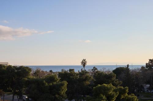 a view of the ocean and a palm tree at Ace Hotel & Swim Club Athens in Athens