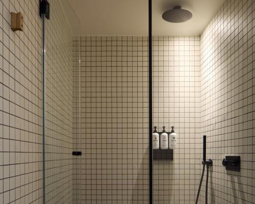 a bathroom with a shower with a glass door at Ace Hotel & Swim Club Athens in Athens