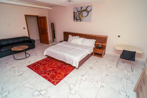a bedroom with a bed and a couch and a table at Baville in Iloneyon-Sekioni