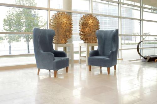 two chairs and a table in a room with windows at Hilton Omaha in Omaha