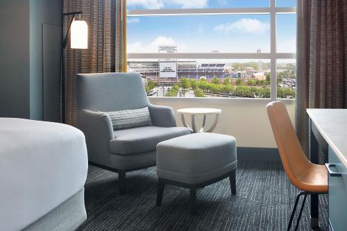 a hotel room with a chair and a bed and a window at Hilton Omaha in Omaha