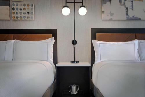 two beds sitting next to each other in a room at Hilton Omaha in Omaha