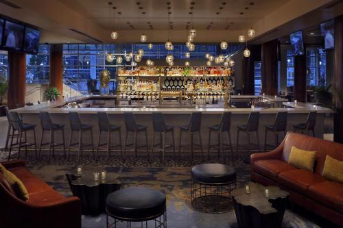 a bar in a restaurant with a bar counter at Hilton Omaha in Omaha