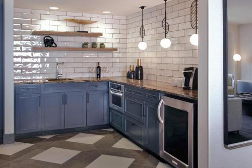 a kitchen with blue cabinets and white tiles at Hilton Omaha in Omaha