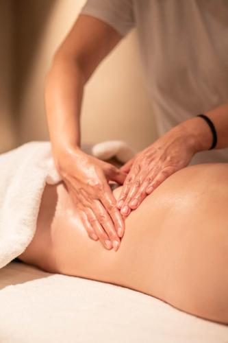 a woman getting a massage from a therapist at Hotel Spitzhorn Superieur in Gstaad