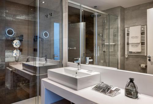 a bathroom with two sinks and a glass shower at Catalonia Gran Vía Madrid in Madrid