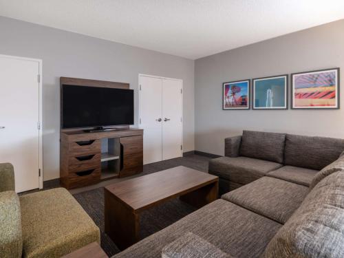 a living room with a couch and a flat screen tv at Hampton Inn West Palm Beach-Florida Turnpike in West Palm Beach