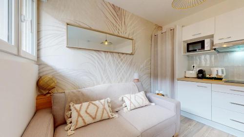 a living room with a couch and a kitchen at expat renting - Le Dolce Vita - Netflix in Toulouse