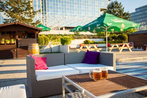 a table with two glasses of beer on a patio at Hilton Prague Hotel in Prague